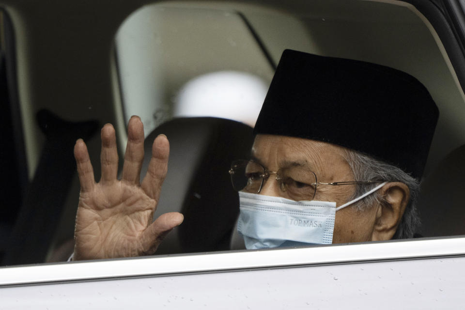 FILE - Malaysia's former Prime Minister Mahathir Mohamad, wearing a face mask, waves as he leaves the National Palace after meeting with the king in Kuala Lumpur, Malaysia, Thursday, June 10, 2021. Former Malaysian Prime Minister Mahathir Mohamad, 96, was hospitalized for the third time in just over a month, his spokesperson said Saturday, Jan. 22, 2022, sparking concerns over his health. (AP Photo/Vincent Thian, File)