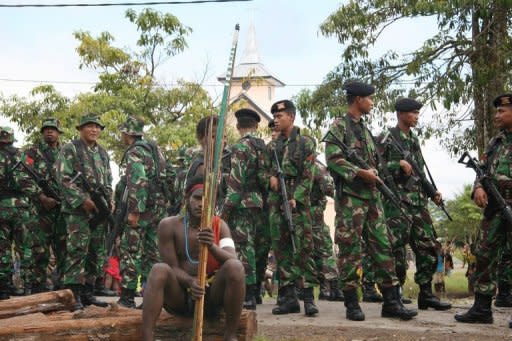 Indonesian soldiers surround a Papuan tribal warrior armed with bow and arrow on June 18. Two tribesmen were killed when rival groups armed with bows and arrows clashed in Indonesia's restive Papua province on Monday, police said