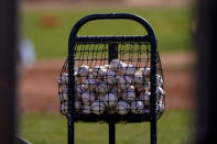 Baseballs sit in a basket at the Seattle Mariners' spring training, Thursday, Feb. 25, 2021, in Peoria, Ariz. (AP Photo/Charlie Riedel)