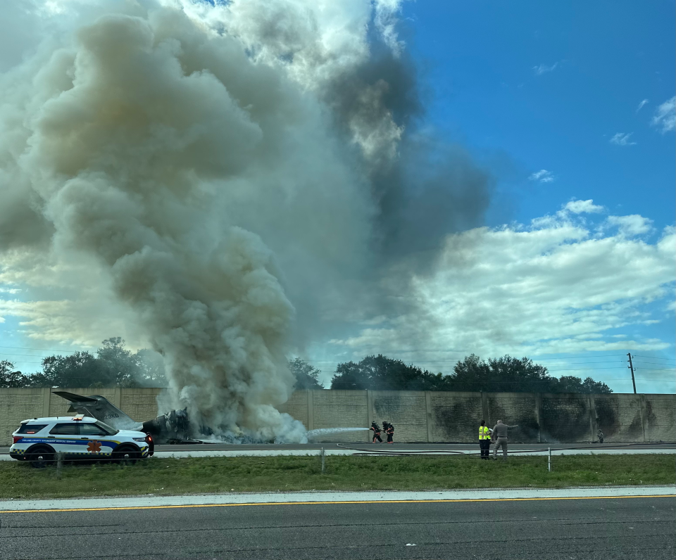 Firefighters hose down the jet that crashed Friday afternoon on I-75 outside Naples. At least two are confirmed dead in the crash.