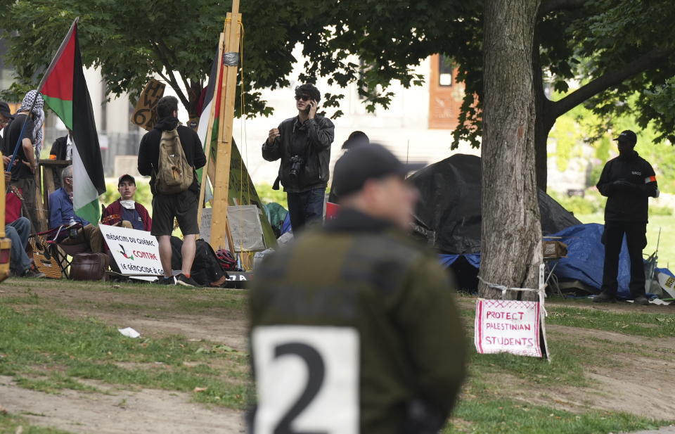 A group of pro-Palestinian protesters remain on their encampment at McGill University in Montreal, Wednesday, July 10, 2024. Police cordoned off the streets surrounding the university as McGill security began to dismantle the encampment. (Christinne Muschi/The Canadian Press via AP)