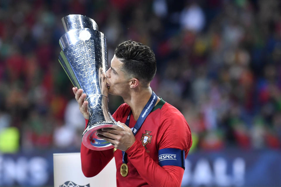 Portugal's Cristiano Ronaldo kisses the trophy as he celebrates with players after winning the UEFA Nations League final soccer match between Portugal and Netherlands at the Dragao stadium in Porto, Portugal, Sunday, June 9, 2019. Portugal won 1-0. (AP Photo/Martin Meissner)