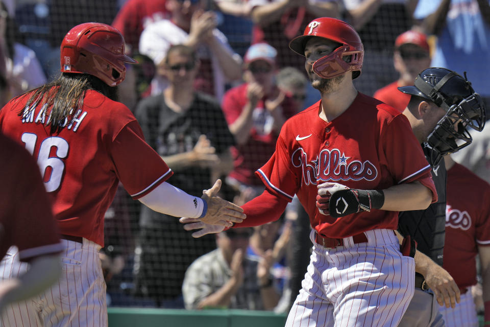 Philadelphia Phillies' Trea Turner shakes hands with Brandon Marsh (16) after Turner hit a two-run home run off Detroit Tigers' Joey Wentz during the fifth inning of a spring training baseball game Thursday, March 23, 2023, in Clearwater, Fla. (AP Photo/Chris O'Meara)