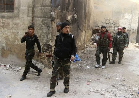 Rebel fighters carry their weapons as they walk near the frontline against forces loyal to Syria's President Bashar al-Assad who are stationed in Aleppo's historic citadel December 7, 2014. Picture taken December 7, 2014. REUTERS/Abdalrhman Ismail