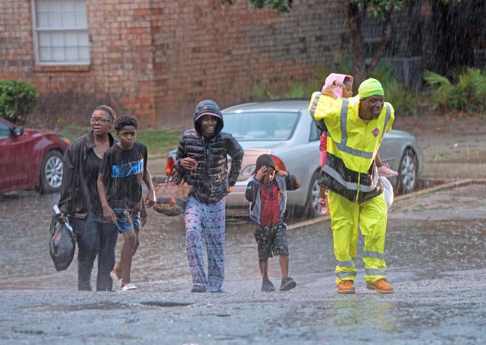 Forest Creek residents flee the rising flood water as heavy rain dumps several inches along the Gulf Coast area on Friday, June 16, 2023.