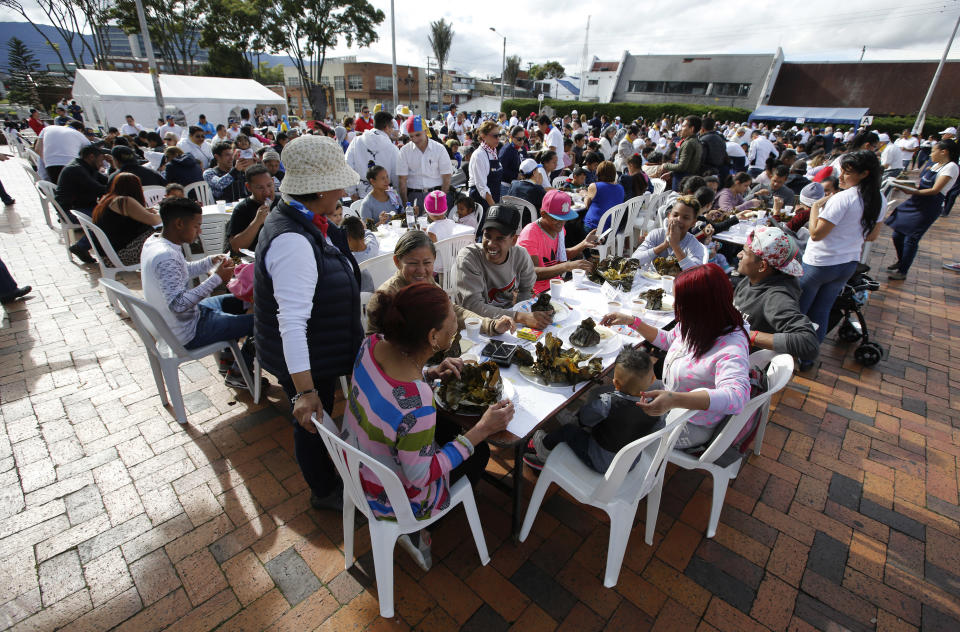 Migrantes venezolanos comparten un desayuno al aire libre organizado por El Minuto de Dios en Bogotá, Colombia, domingo 18 de noviembre de 2018. (AP Foto/Fernando Vergara)