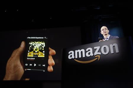 Amazon CEO Jeff Bezos shows off his company's new Fire smartphone at a news conference in Seattle, Washington in this June 18, 2014 file photo. REUTERS/Jason Redmond/Files