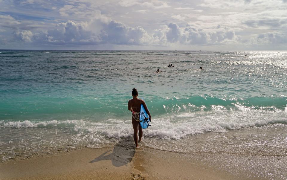 Surfers launch from Kahanamoku Beach in Honolulu