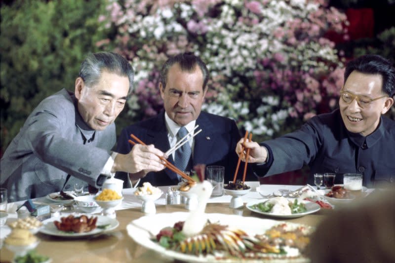 President Richard Nixon tries his luck at eating with chopsticks during the farewell banquet upon completion of his historic visit to China in 1972. At left is premier Chou En-Lai and at right is Communist Party Leader Chang Chung-chiao. File Photo by Dirck Halstead/UPI