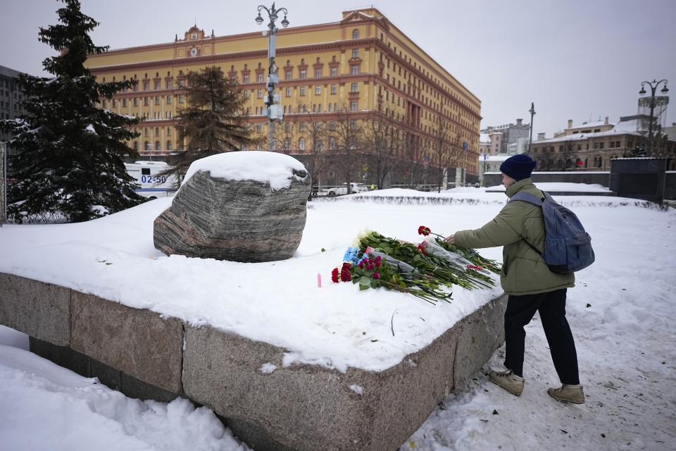 Una mujer deposita flores en homenaje a Alexei Navalny en un monumento a las víctimas de los gulags, frente a la sede del Servicio Federal de Seguridad, en Moscú, Rusia, el 17 de febrero de 2024. (AP Foto/Alexander Zemlianichenko)