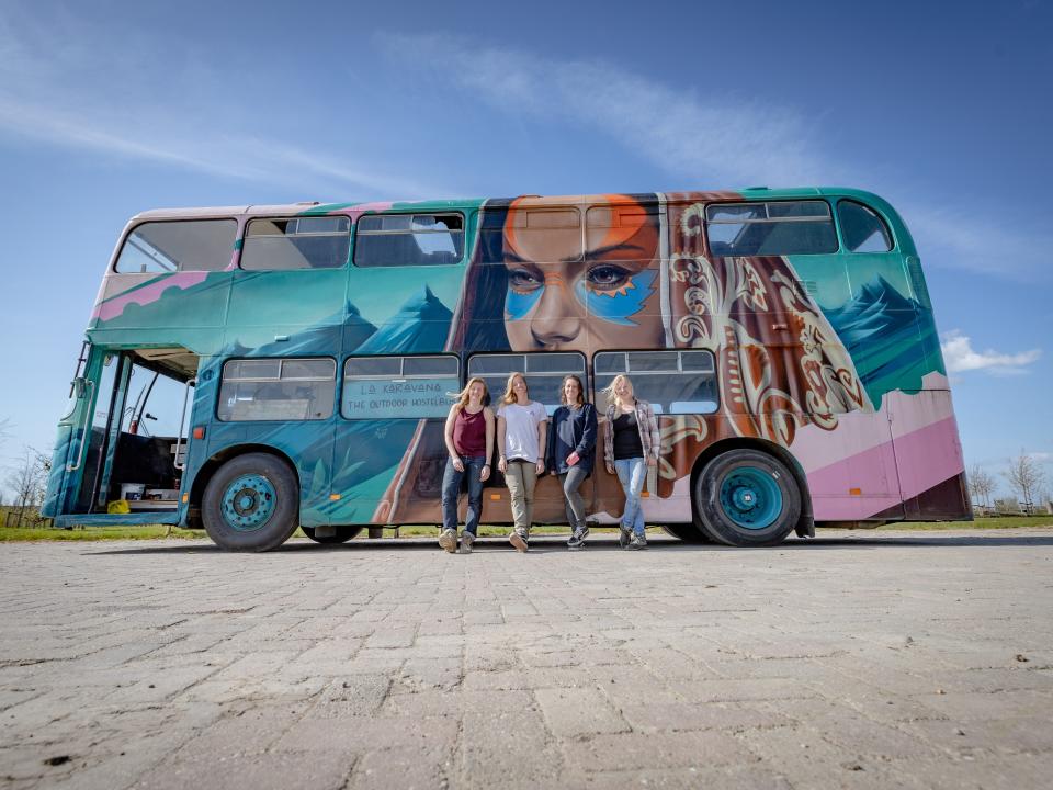 the four women in front of the finished double decker bus