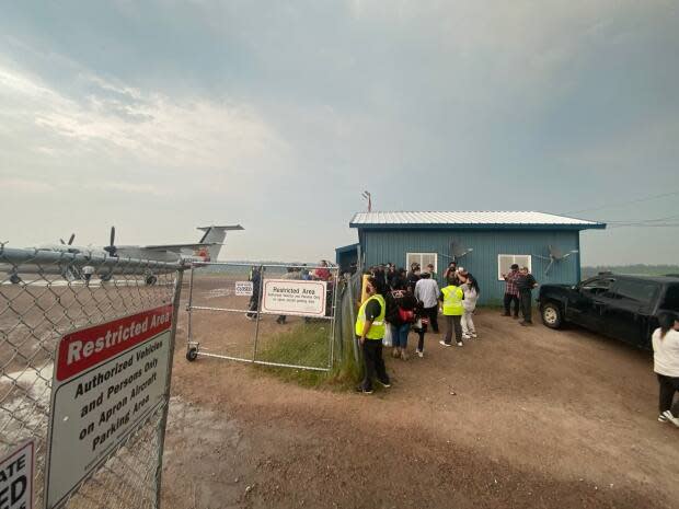 Residents from Deer Lake First Nation wait for a plane to take them to southern Ontario last week. The community was evacuated due to forest fire activity. (Breanne Meekis - image credit)