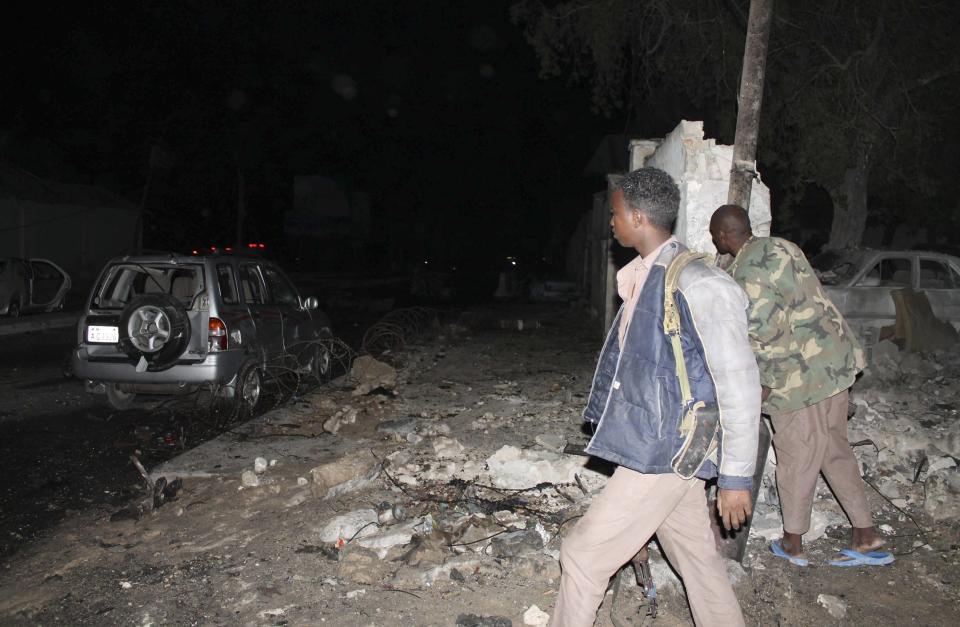 Police officers assess the scene of an explosion outside the Jazira hotel in Mogadishu, January 1, 2014. Three bombs exploded within an hour outside the hotel in a heavily fortified district of the Somali capital on Wednesday, killing at least 11 people. (REUTERS/Feisal Omar)