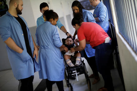 Jackeline Vieira de Souza (R), 28, mother of Daniel Vieira stands by as Daniel, who is two years old, and was born with microcephaly, reacts to stimulus during an evaluation session with a physiotherapist at the Association of Parents and Friends of the Exceptional (APAE) in Recife, Brazil, August 7, 2018. A few years ago Jackeline fought to overcome a very rare complication from an earlier pregnancy, and then survived cancer. "My dream was to be a mother again," she says. In 2015, she got her wish. But during her pregnancy, she learned that her son had microcephaly. "When he was born, I fell in love with him because I knew he would be a good thing in my life, even with the difficulties I would have to face." Daniel's father separated from Jackeline shortly after learning that his son had microcephaly. He pays a small amount of family support every month, in addition to a monthly check that Jackeline gets from the government. REUTERS/Ueslei Marcelino