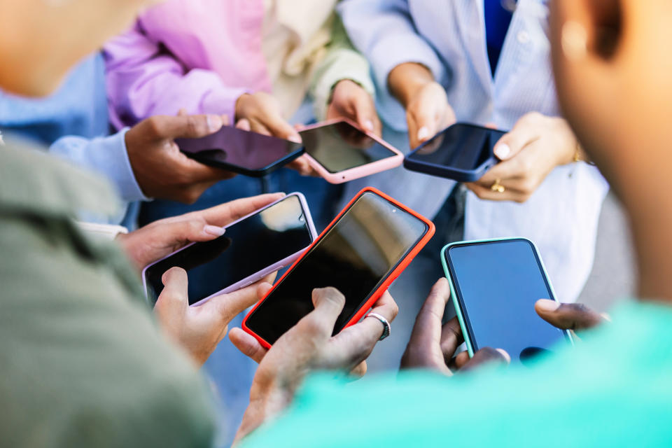 group of kids looking at their phones