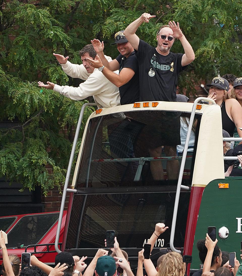 Milwaukee Bucks head coach Mike Budenholzer, right, with Bucks president Peter Feigin, right, cheer from a bus as part of the celebration of the Milwaukee Bucks' NBA championship in the downtown Deer District near Fiserv Forum in Milwaukee July 22, 2021.