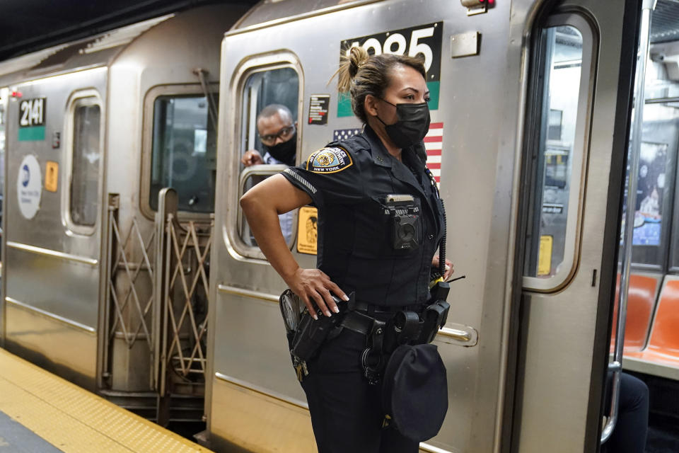 FILE - A New York City Police Department officer and a subway conductor look down the subway platform at the Grand Central subway station, in New York, on May 18, 2021. New York Mayor Eric Adams is announcing a plan to boost safety in the city's sprawling subway network and try to stop homeless people from sleeping on trains or living in stations. (AP Photo/Frank Franklin II, File)