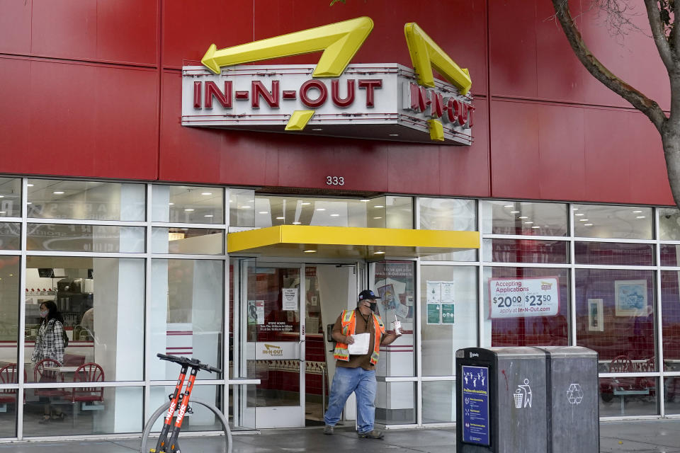 A customer carries food while exiting an In-N-Out restaurant in San Francisco's Fisherman's Wharf, Wednesday, Oct. 20, 2021. The In-N-Out hamburger chain is sizzling mad after San Francisco shut down its indoor dining for refusing to check customers' vaccination status. The company's Fisherman's Wharf location, its only one in San Francisco, was temporarily shut by the Department of Public Health on Oct. 14. (AP Photo/Jeff Chiu)