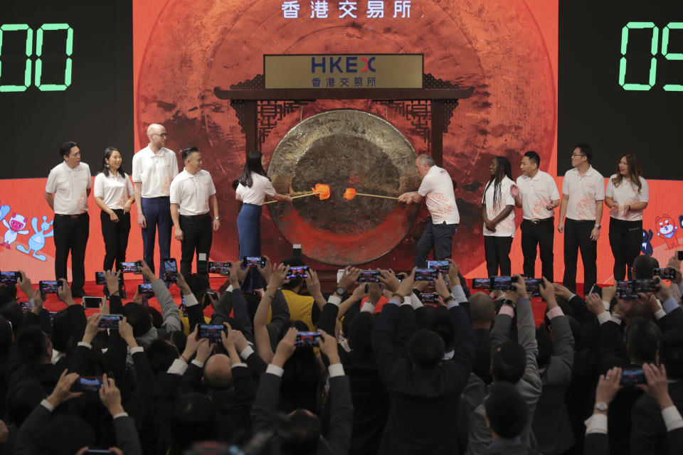 Members of Alibaba Group's digital economy customers and partners hit the gong during the Alibaba Group's listing ceremony at the Hong Kong Stock Exchange (HKEX) in Hong Kong, Tuesday, Nov. 26, 2019. (AP Photo/Kin Cheung)