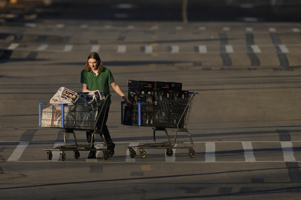 FILE - A shopper leaves a Walmart after attending a Black Friday sale Friday, Nov. 25, 2022, in Shawnee, Kan. The Federal Reserve is set to raise its benchmark short-term rate on Wednesday, Dec. 14, for a seventh time this year, though by a smaller amount than it has recently. (AP Photo/Charlie Riedel, File)