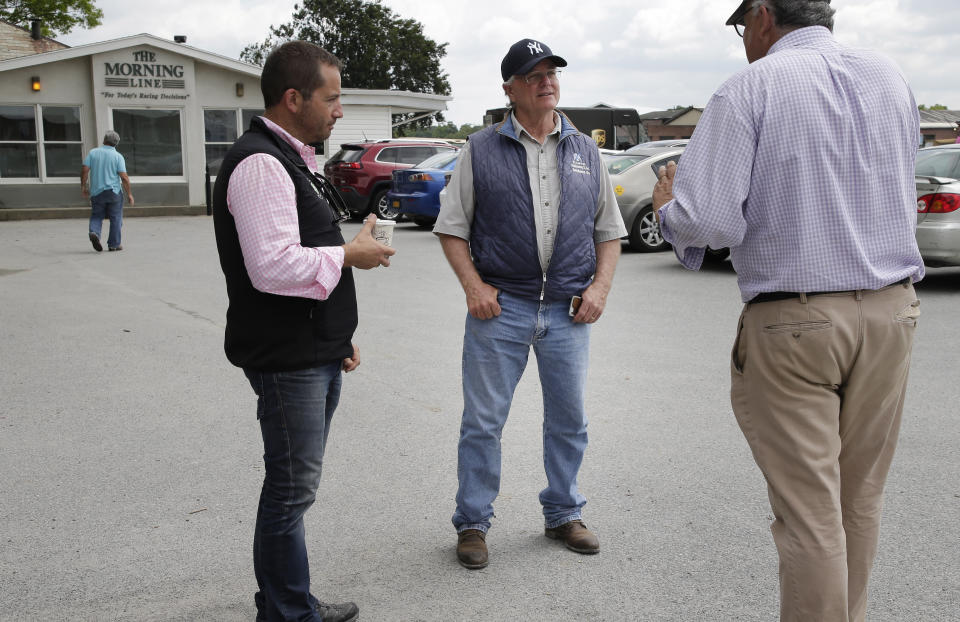 Trainer Bill Mott, second from right, stops to talk to people at Belmont Park in Elmont, N.Y., Thursday, June 6, 2019. The 151st Belmont Stakes horse race will be run on Saturday, June 8, 2019. (AP Photo/Seth Wenig)