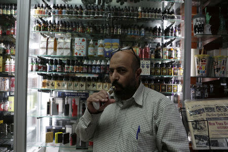 Manager of Brooklyn Vape store Mohammed Isa smokes an e-cigarette in Brooklyn, New York, U.S., January 18, 2017. REUTERS/Joe Penney