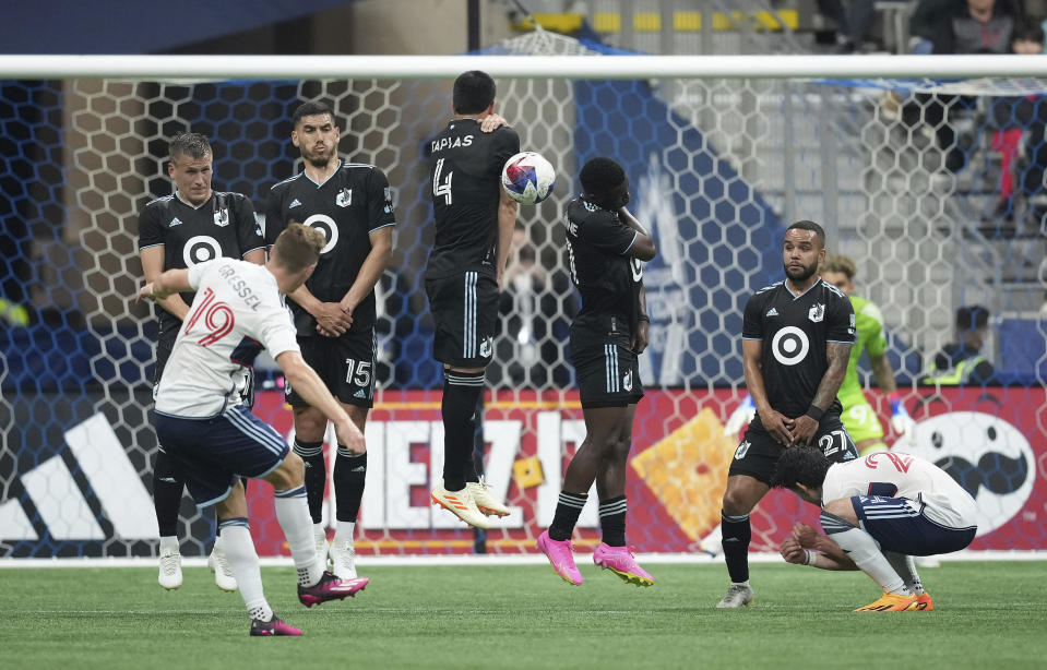 Minnesota United's Robin Lod, back from left to right, Michael Boxall, Miguel Tapias, Bongokuhle Hlongwane and DJ Taylor defend as Vancouver Whitecaps' Julian Gressel (19) takes a free kick during the first half of an MLS soccer match in Vancouver, British Columbia., Saturday, May 6, 2023. (Darryl Dyck/The Canadian Press via AP)