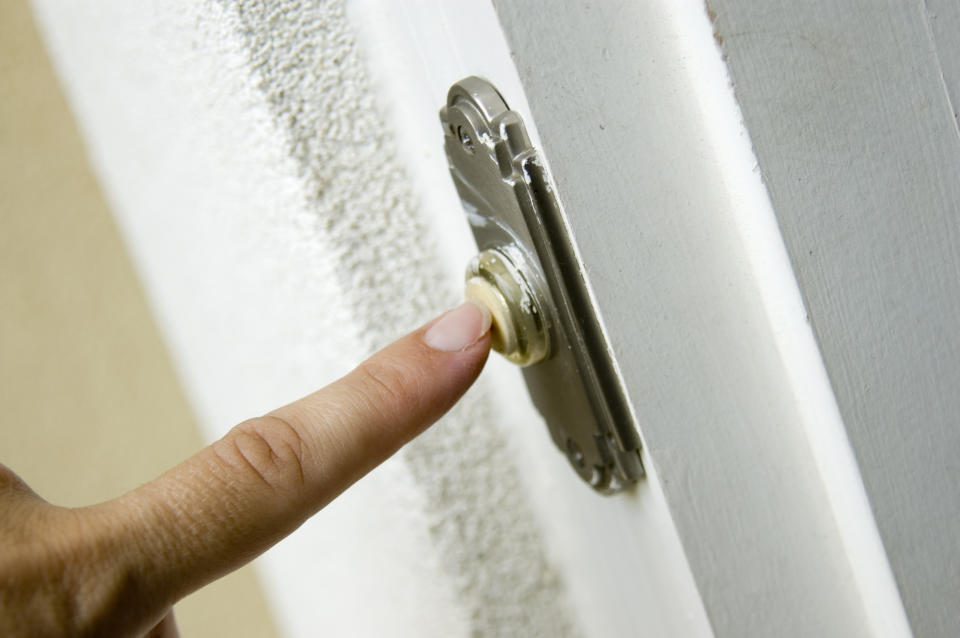 finger ringing the doorbell