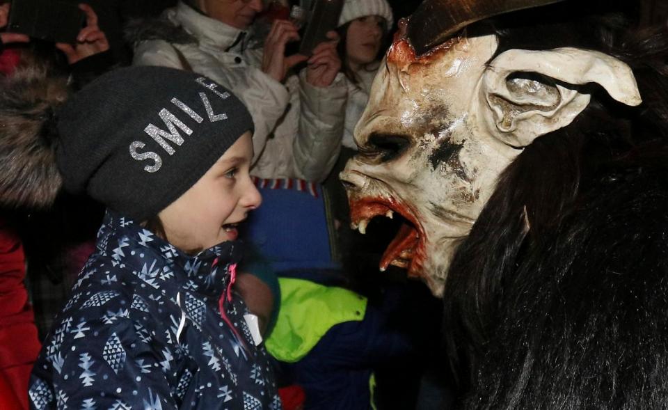 A Krampus scares spectators during a traditional Krampus run in which men and women dress up as pagan Krampus figures to scare people in Hollabrunn, Austria. (AP)