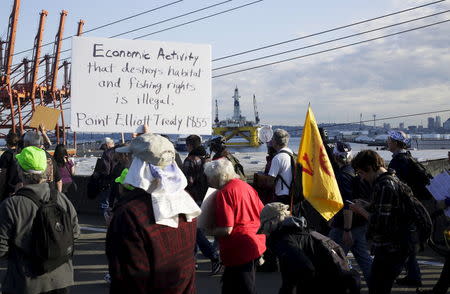 Shell Oil Company's drilling rig Polar Pioneer is seen in the background as activists march to the entrance of Terminal 5 at the Port of Seattle, Washington May 18, 2015. REUTERS/Jason Redmond