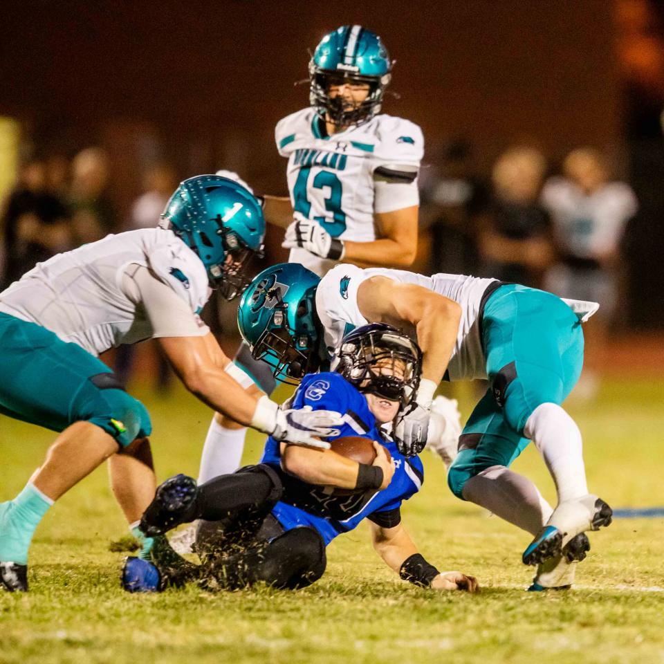 Highland middle linebacker Kash Cullimore (1) and offensive linebacker Cole McCleve (7) block Chandler quarterback Blake Heffron (10) at Chandler High School's football field in Chandler on Sept. 22, 2023.