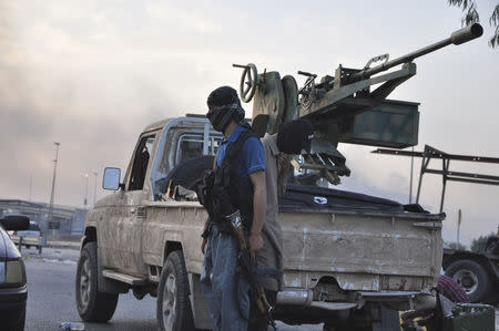 Fighters of the Islamic State of Iraq and the Levant (ISIL) stand guard at a checkpoint in the northern Iraq city of Mosul, June 11, 2014. REUTERS/Stringer