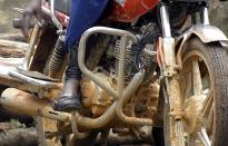 Congolese motorbike taxi rider Imelda Mmambu adjusts her motorbike as she waits for clients along the streets of Beni