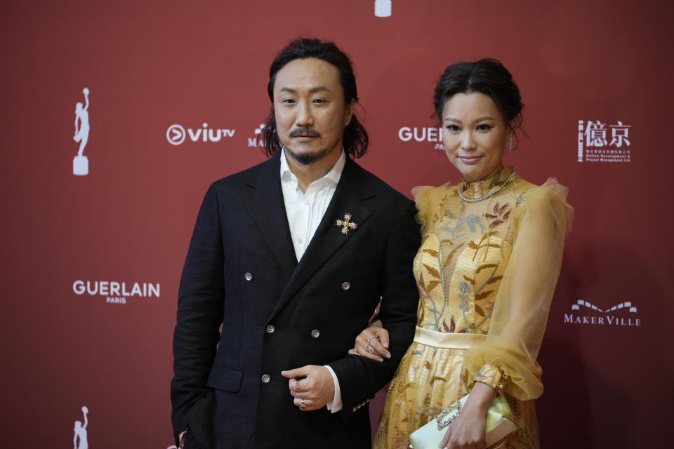 Hong Kong actor Ronald Cheng, left, poses with his wife on red carpet at the Hong Kong Film Awards, Sunday, July 17, 2022. (AP Photo/Kin Cheung)
