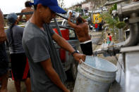 <p>People fill containers with water on the street after the area was hit by Hurricane Maria in Toa Baja, Puerto Rico September 24, 2017. (Photo: Carlos Garcia Rawlins/Reuters) </p>