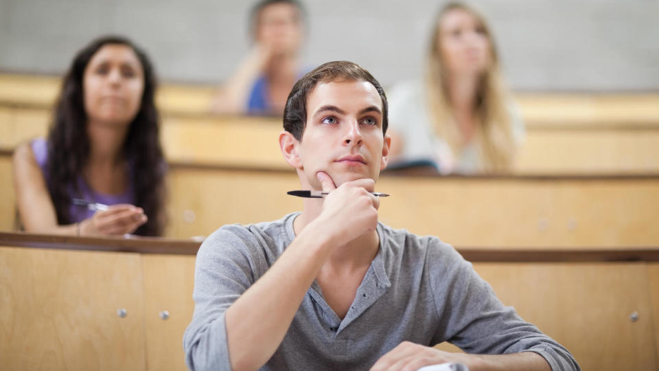 Serious students listening during a lecture with the camera focus on the foreground.