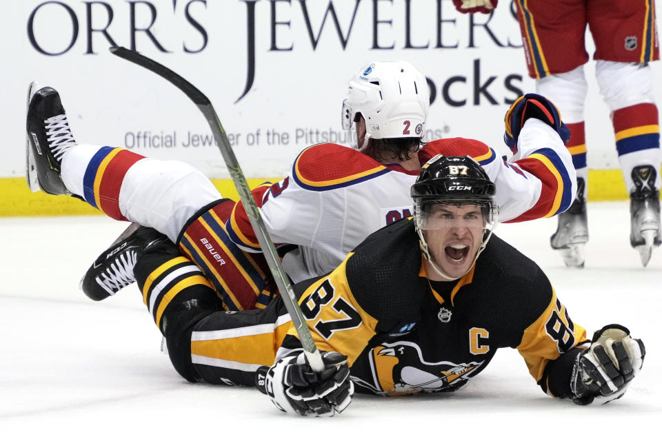 New Jersey Devils' Brendan Smith (2) collides with Pittsburgh Penguins' Sidney Crosby (87) during the second period of an NHL hockey game in Pittsburgh, Friday, Dec. 30, 2022. (AP Photo/Gene J. Puskar)