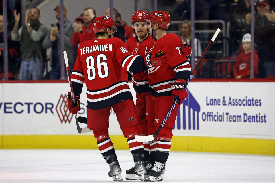 Carolina Hurricanes' Teuvo Teravainen (86) and Sebastian Aho, center, congratulate Tony DeAngelo, right, on his goal against the Buffalo Sabres during the first period of an NHL hockey game in Raleigh, N.C., Tuesday, Nov. 7, 2023. (AP Photo/Karl B DeBlaker)