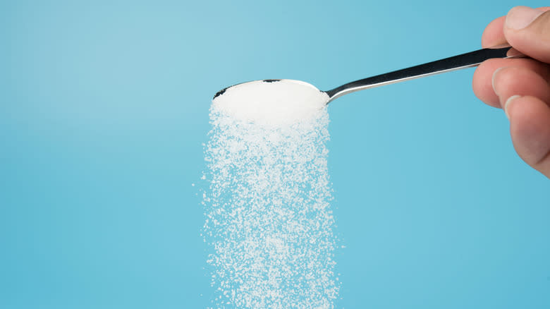 pouring sugar from spoon