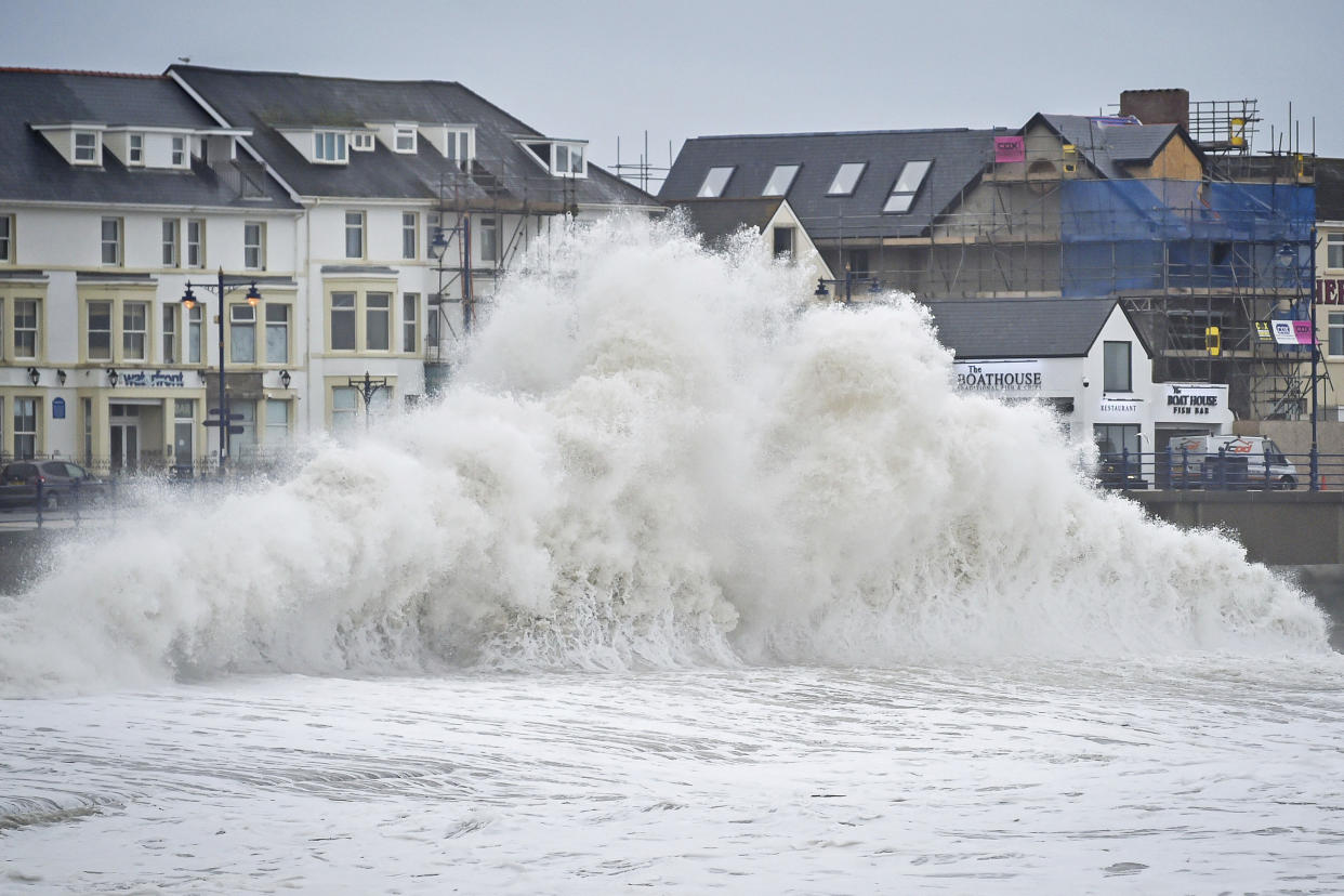 Huge waves hit the sea wall in Porthcawl, Wales, Tuesday Jan. 14, 2020, as gales of up to 80mph from storm Brendan caused disruption around the UK. (Ben Birchall/PA via AP)