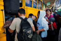 People in a caravan of migrants departing from El Salvador en route to the United States wait to board a bus, in San Salvador, El Salvador, November 18, 2018. REUTERS/Jose Cabezas