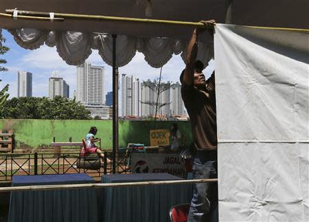 A volunteer makes preparations at a polling station for the upcoming parliamentary election in Jakarta April 8, 2014. REUTERS/Beawiharta