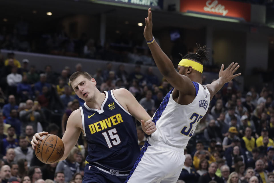 Denver Nuggets' Nikola Jokic (15) goes to the basket against Indiana Pacers' Myles Turner (33) during the first half of an NBA basketball game Thursday, Jan. 2, 2020, in Indianapolis. (AP Photo/Darron Cummings)