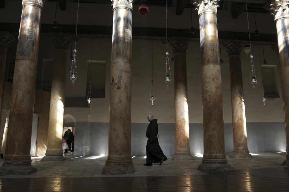 A priest walks at the Church of the Nativity, traditionally believed to be the birthplace of Jesus Christ in the West Bank town of Bethlehem, Saturday, Dec. 16, 2023. World-famous Christmas celebrations in Bethlehem have been put on hold due to the ongoing Israel-Hamas war. (AP Photo/Mahmoud Illean)