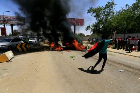 A Sudanese protester gestures as they burn tyres and barricade the road leading to al-Mek Nimir Bridge crossing over Blue Nile; that links Khartoum North and Khartoum, in Sudan May 13, 2019. REUTERS/Mohamed Nureldin Abdallah