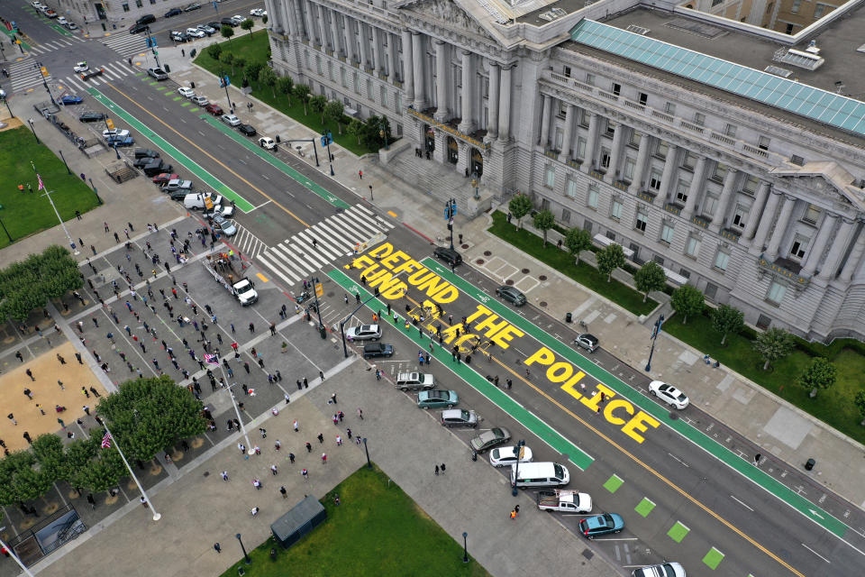 Protesters paint: Defund the police. The painted words are seen on the street during a demonstration outside San Francisco City Hall.