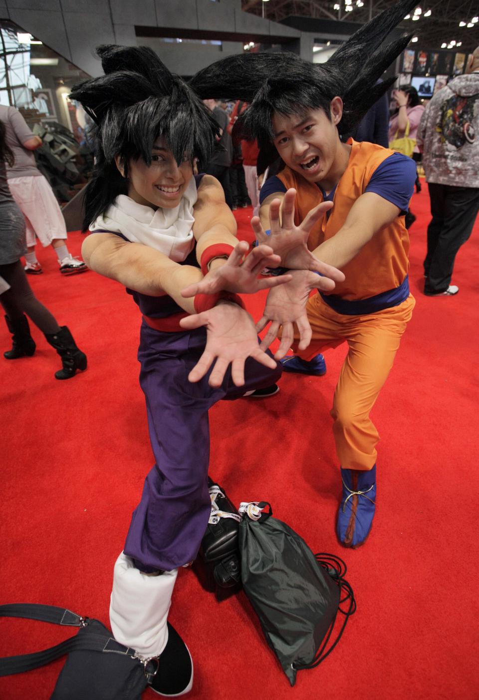 Nikki Warner, as Gohan, left, and Mike Chan, as Goku, from Dragonball Z, pose for photos at New York Comic Con 2012 at New York's Jacob K. Javits Center, Thursday, Oct. 11, 2012. The New York Comic Con show floor plays host to the latest and greatest in comics, graphic novels, anime, manga, video games, toys, movies, and television. (AP Photo/Richard Drew)