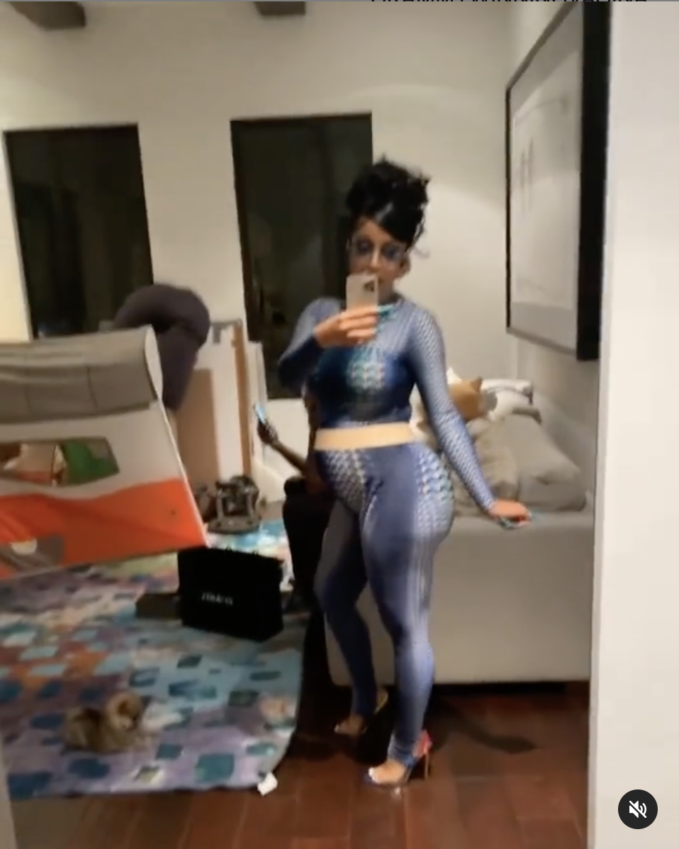 A side profile of Cardi in the bodysuit that shows she's clearly pregnant