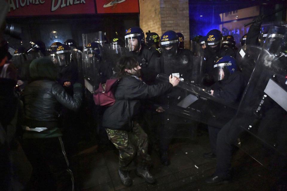 Police officers move in on demonstrators during the "Kill The Bill" protest in Bristol, England, Friday, March 26, 2021. Protesters are calling to protect free speech and protesting against new powers to be given to the police to impose conditions on non-violent protests, including those deemed too noisy or a nuisance. (Ben Birchall/PA via AP)