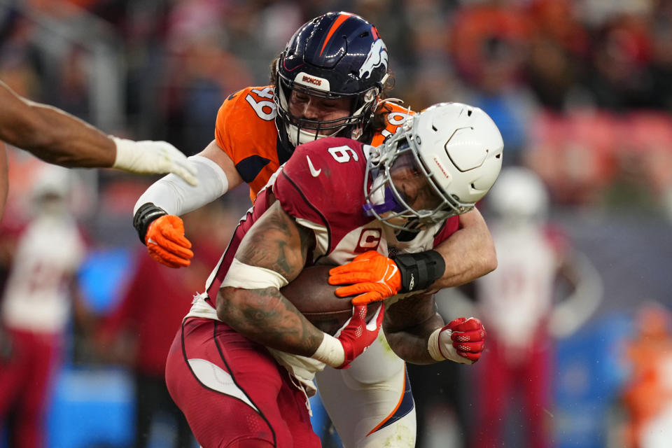 Arizona Cardinals running back James Conner (6) is hit by Denver Broncos linebacker Alex Singleton (49) during the second half of an NFL football game, Sunday, Dec. 18, 2022, in Denver. (AP Photo/Jack Dempsey)